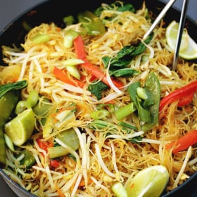 Simple One Pan Singapore Noodles recipe made from rice vermicelli (thin rice noodles), curry powder, bean sprouts, bok choy, spring onion, carrots, red pepper, snow peas, and a ton of other nutritious and easy-to-get ingredients. Vegan, gluten-free, and healthy! #singaporenoodles #noodles #recipe #onepan #asian #vegan #glutenfree #ricenoodles #vermicelli