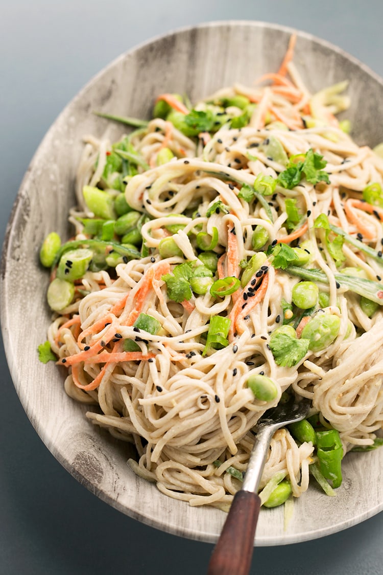 Japanese inspired Soba Noodles with edamame, carrot and cucumber - tossed in a delicious Miso Tahini Dressing. Vegan and Gluten Free. #vegan #japanese #asian #soba #healthy #foodporn #tahini #ginger #noodles