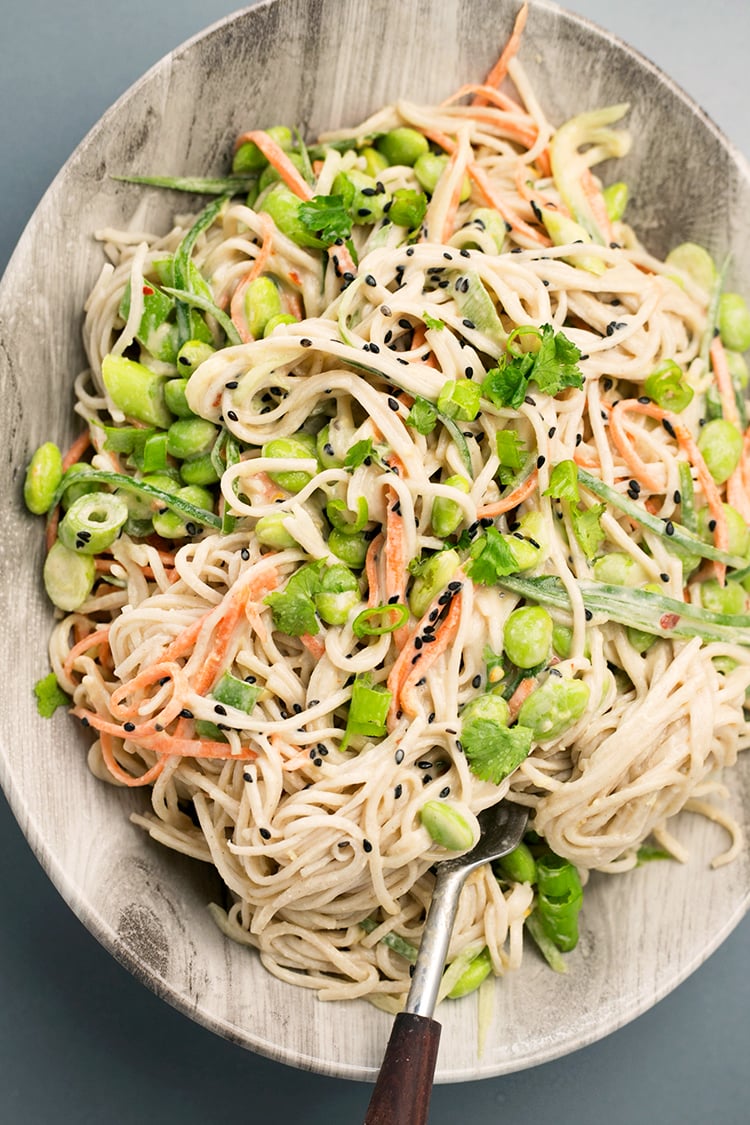 Japanese inspired Soba Noodles with edamame, carrot and cucumber - tossed in a delicious Miso Tahini Dressing. Vegan and Gluten Free. #vegan #japanese #asian #soba #healthy #foodporn #tahini #ginger #noodles