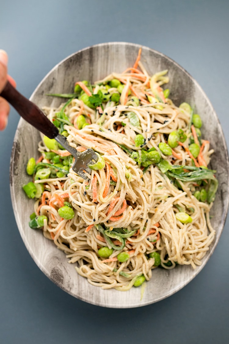 Japanese inspired Soba Noodles with edamame, carrot and cucumber - tossed in a delicious Miso Tahini Dressing. Vegan and Gluten Free. #vegan #japanese #asian #soba #healthy #foodporn #tahini #ginger #noodles