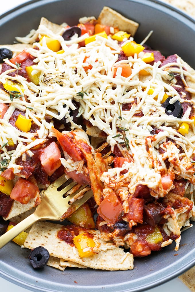 Vegan Pizza Nachos - a combination of Pizza Toppings and Tortilla Crisps, baked to perfection. #vegan #pizza #nachos #fusion #cheese #chips