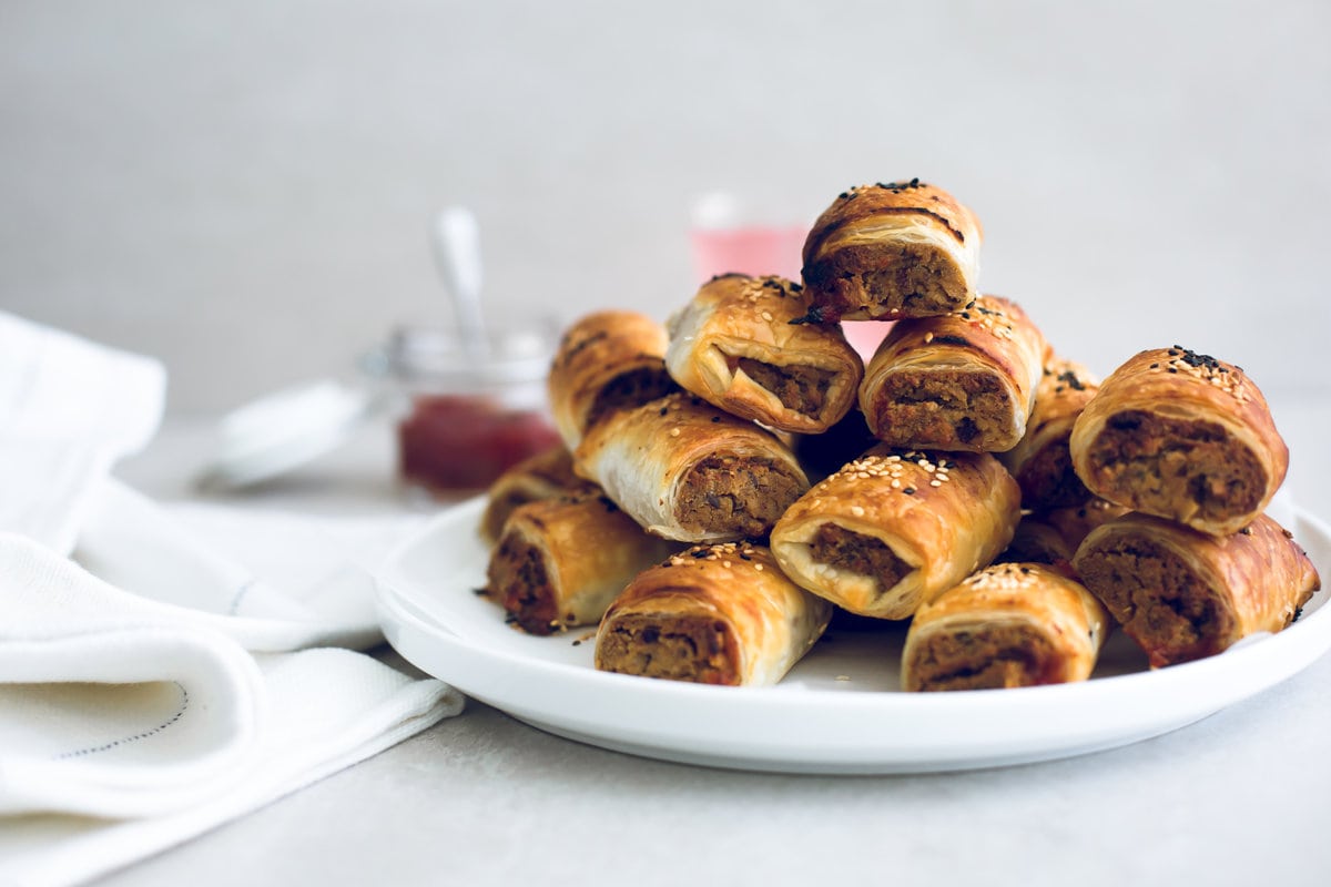 Delicious Vegan Tofu Sausage Rolls - Tofu and Nut Sausage Mince encased in golden and flaky Puff Pastry, served with Tomato Sauce. Perfect for parties and picnics. #vegan #tofu #sausagerolls #vegansausagerolls #simple #delicious #puffpastry #nuts 
