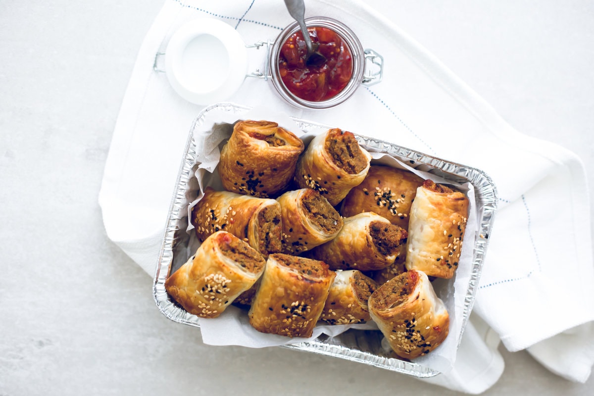 Delicious Vegan Tofu Sausage Rolls - Tofu and Nut Sausage Mince encased in golden and flaky Puff Pastry, served with Tomato Sauce. Perfect for parties and picnics. #vegan #tofu #sausagerolls #vegansausagerolls #simple #delicious #puffpastry #nuts 