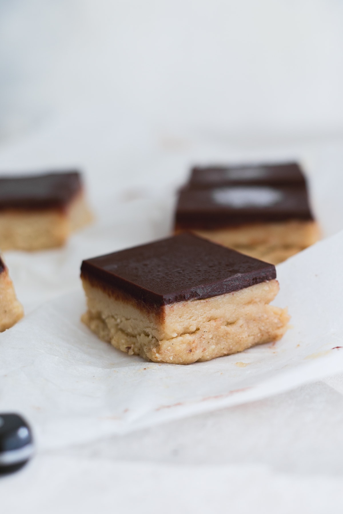 A delicious Raw Vegan Tahini Caramel Slice topped with Chocolate - easy to make, full of wholesome ingredients and completely DATE FREE. #simple #raw #vegan #chocolate #caramel #tahini #caramelslice #datefree #healthy #rawfood #desserts #plantbased