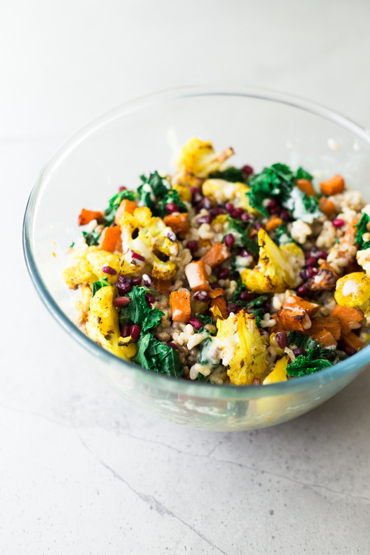 A delicious, protein packed Vegan Roasted Cauliflower and Brown Rice Salad with a creamy Tahini Garlic Dressing. Gluten Free, Fuss Free, YUM! #brownrice #lentil #salad #veganrecipes #simplerecipes #cauliflower #turmeric #roasted #sweetpotato #kale #delicious