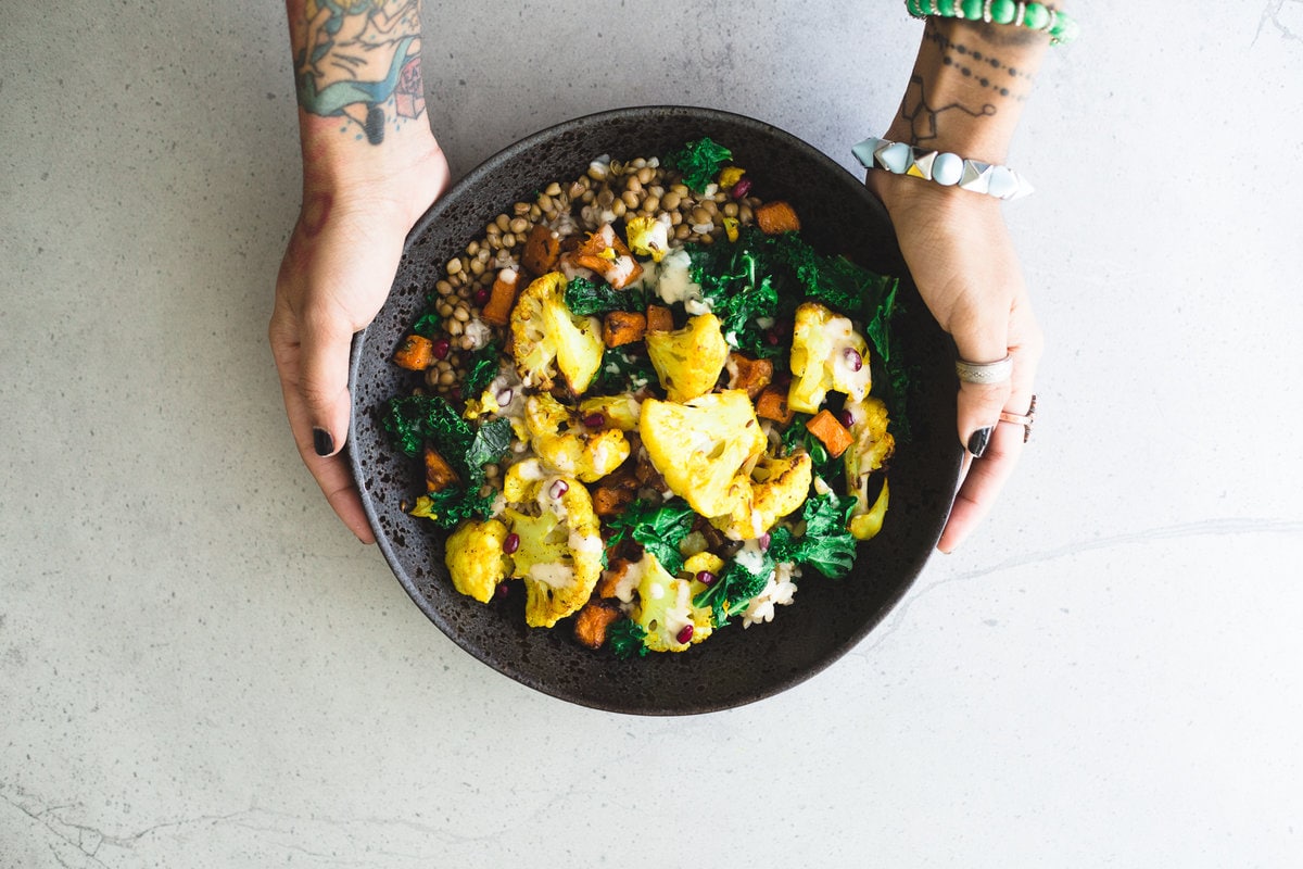 A delicious, protein packed Vegan Roasted Cauliflower and Brown Rice Salad with a creamy Tahini Garlic Dressing. Gluten Free, Fuss Free, YUM! #brownrice #lentil #salad #veganrecipes #simplerecipes #cauliflower #turmeric #roasted #sweetpotato #kale #delicious