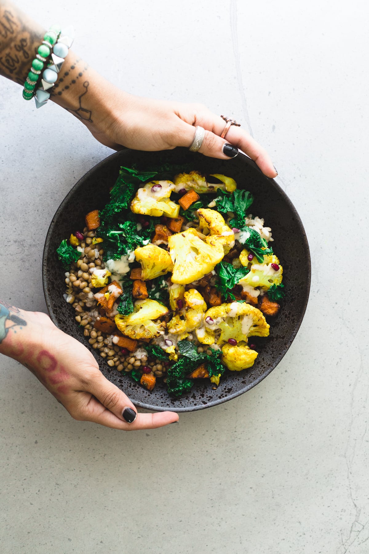A delicious, protein packed Vegan Roasted Cauliflower and Brown Rice Salad with a creamy Tahini Garlic Dressing. Gluten Free, Fuss Free, YUM! #brownrice #lentil #salad #veganrecipes #simplerecipes #cauliflower #turmeric #roasted #sweetpotato #kale #delicious