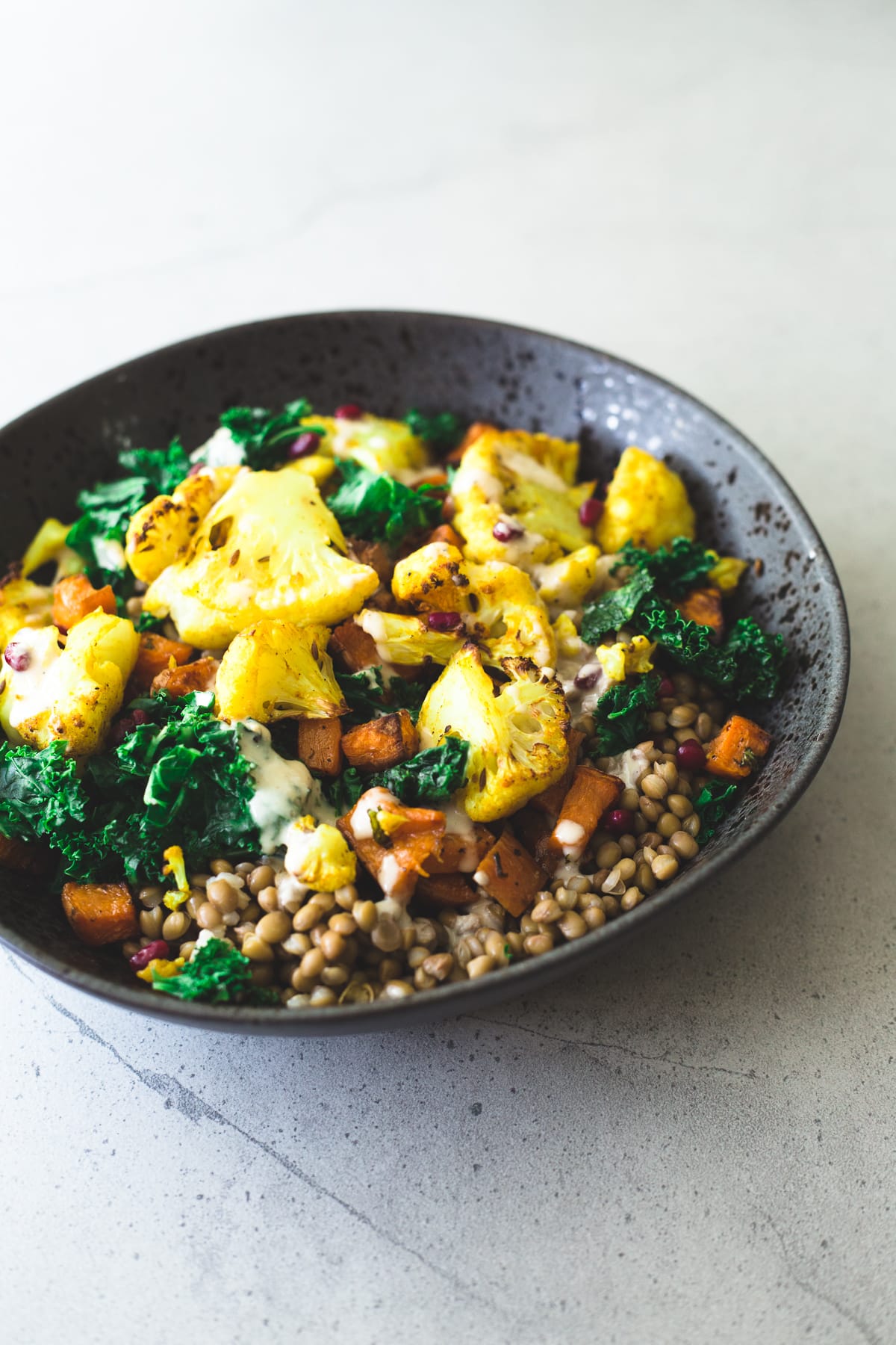 A delicious, protein packed Vegan Roasted Cauliflower and Brown Rice Salad with a creamy Tahini Garlic Dressing. Gluten Free, Fuss Free, YUM! #brownrice #lentil #salad #veganrecipes #simplerecipes #cauliflower #turmeric #roasted #sweetpotato #kale #delicious