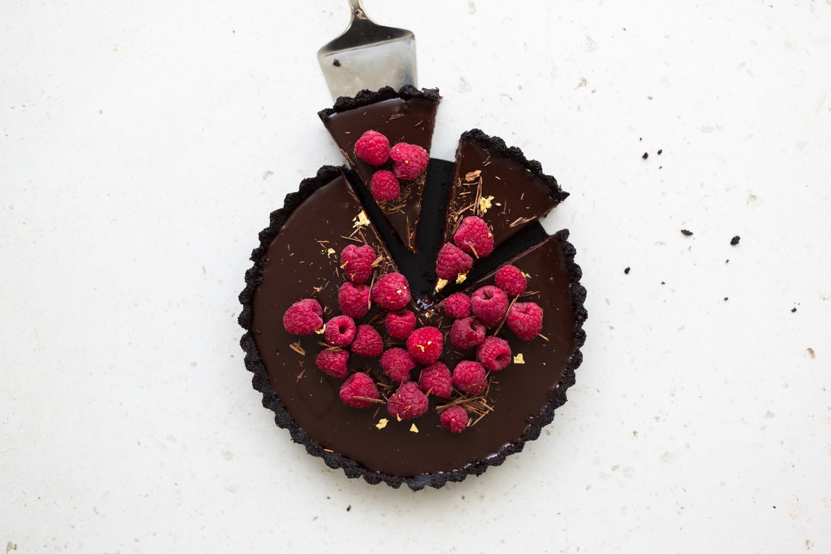 Wow your friends with this simple, delicious and quick Vegan Chocolate Ganache Tart recipe. Made in under 30 minutes and with only 6 ingredients! #chocolate #ganache #tart #simple #oreo #nobake #raspberry #nocook #chocolatetart #vegan #plantbased