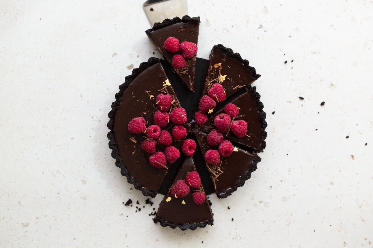 Wow your friends with this simple, delicious and quick Vegan Chocolate Ganache Tart recipe. Made in under 30 minutes and with only 6 ingredients! #chocolate #ganache #tart #simple #oreo #nobake #raspberry #nocook #chocolatetart #vegan #plantbased