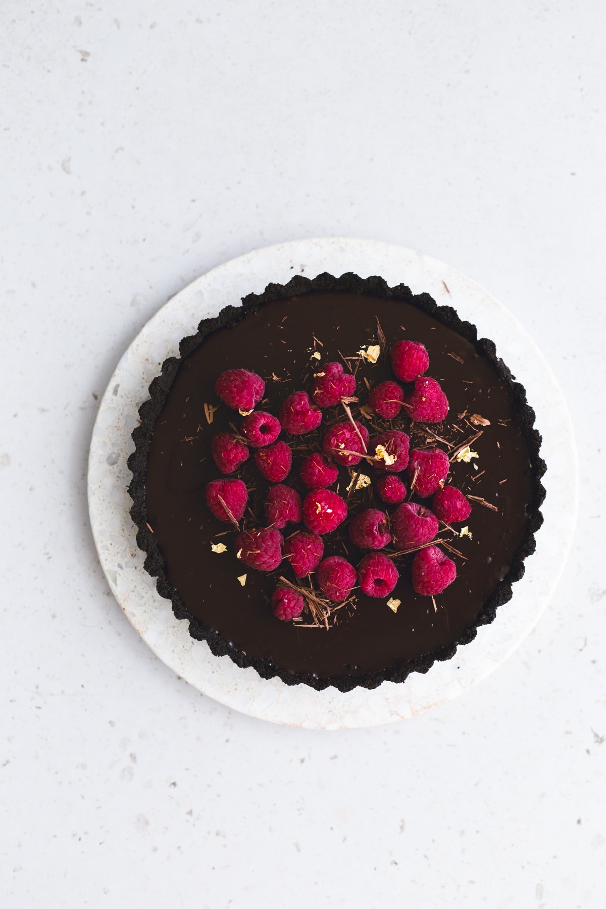 Wow your friends with this simple, delicious and quick Vegan Chocolate Ganache Tart recipe. Made in under 30 minutes and with only 6 ingredients! #chocolate #ganache #tart #simple #oreo #nobake #raspberry #nocook #chocolatetart #vegan #plantbased
