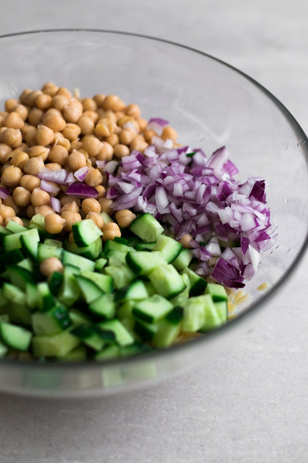 A delicious, fresh and bright Vegan Lemon Orzo Salad with Chickpeas. Ready in under 30 minutes and bursting with fresh Veggies and Herbs. #vegan #orzo #herbs #salad #healthy #simple #chickpeas #lemon #dressing #fast 