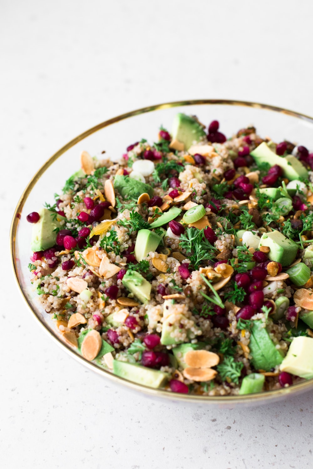 A delicious Vegan Quinoa Crunch Salad studded with toasted Almond, Pistachio and Pomegranate. Perfect for a healthy lunch or as a potluck dish! #quinoa #christmas #holidays #pomegranate #orange #healthy #glutenfree #salad #avocado #pistachio #almond 