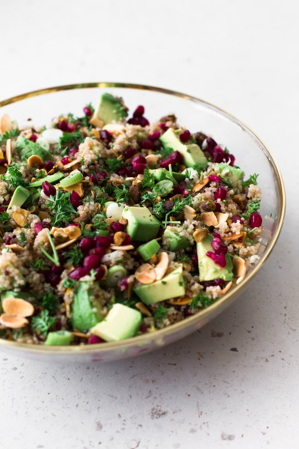 A delicious Vegan Quinoa Crunch Salad studded with toasted Almond, Pistachio and Pomegranate. Perfect for a healthy lunch or as a potluck dish! #quinoa #christmas #holidays #pomegranate #orange #healthy #glutenfree #salad #avocado #pistachio #almond 