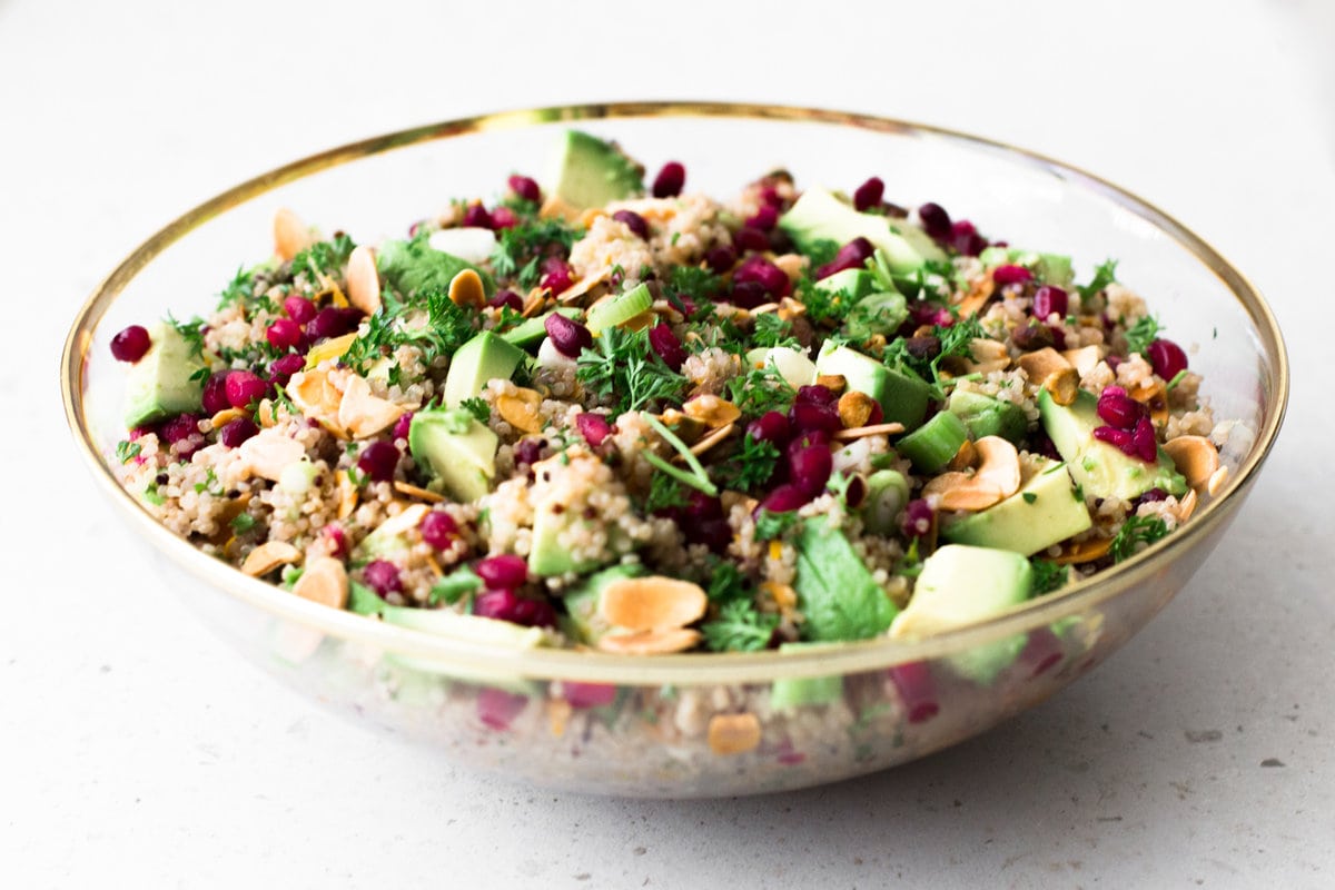 A delicious Vegan Quinoa Crunch Salad studded with toasted Almond, Pistachio and Pomegranate. Perfect for a healthy lunch or as a potluck dish! #quinoa #christmas #holidays #pomegranate #orange #healthy #glutenfree #salad #avocado #pistachio #almond 