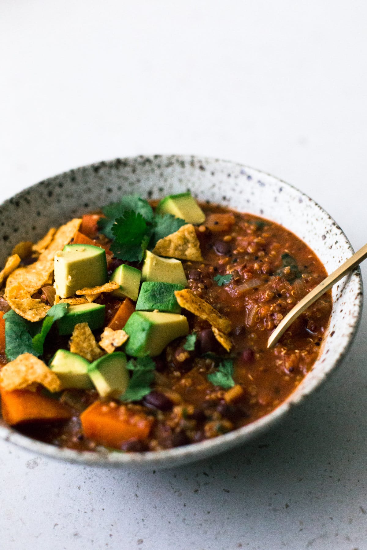 A delicious and hearty one pot Vegan Sweet Potato and Quinoa Chili. Ready in under one hour, Gluten Free, Low in Fat and made with common pantry staples. #vegan #chili #quinoa #healthy #simple #stew #hearty #veganchili #vegetarian #tomato #beans #onepot #mexican #soup #tortilla 