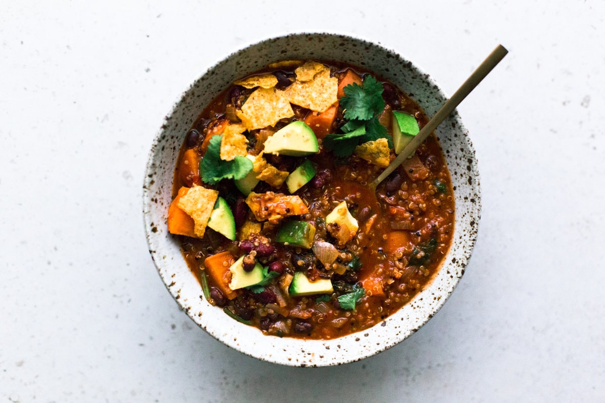 A delicious and hearty one pot Vegan Sweet Potato and Quinoa Chili. Ready in under one hour, Gluten Free, Low in Fat and made with common pantry staples. #vegan #chili #quinoa #healthy #simple #stew #hearty #veganchili #vegetarian #tomato #beans #onepot #mexican #soup #tortilla 