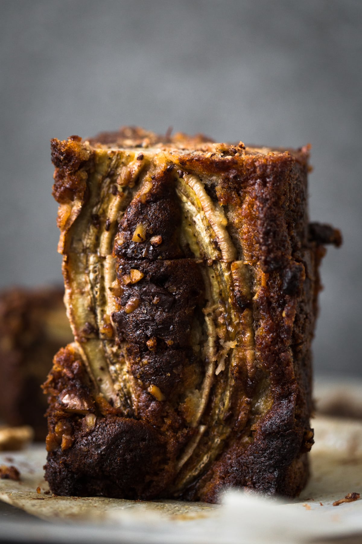 A delicious Vegan Banana Bread recipe loaded with Walnuts, Dark Chocolate and a Brown Sugar Cinnamon Swirl in the middle. Ready in under 1 hour. #bananabread #vegan #cinnamon #cinnamonswirl #quickbread #bananamuffins #veganbaking #veganbananabread #easy #simple #walnuts #chocolate #eggless #baking #dessert #breakfast