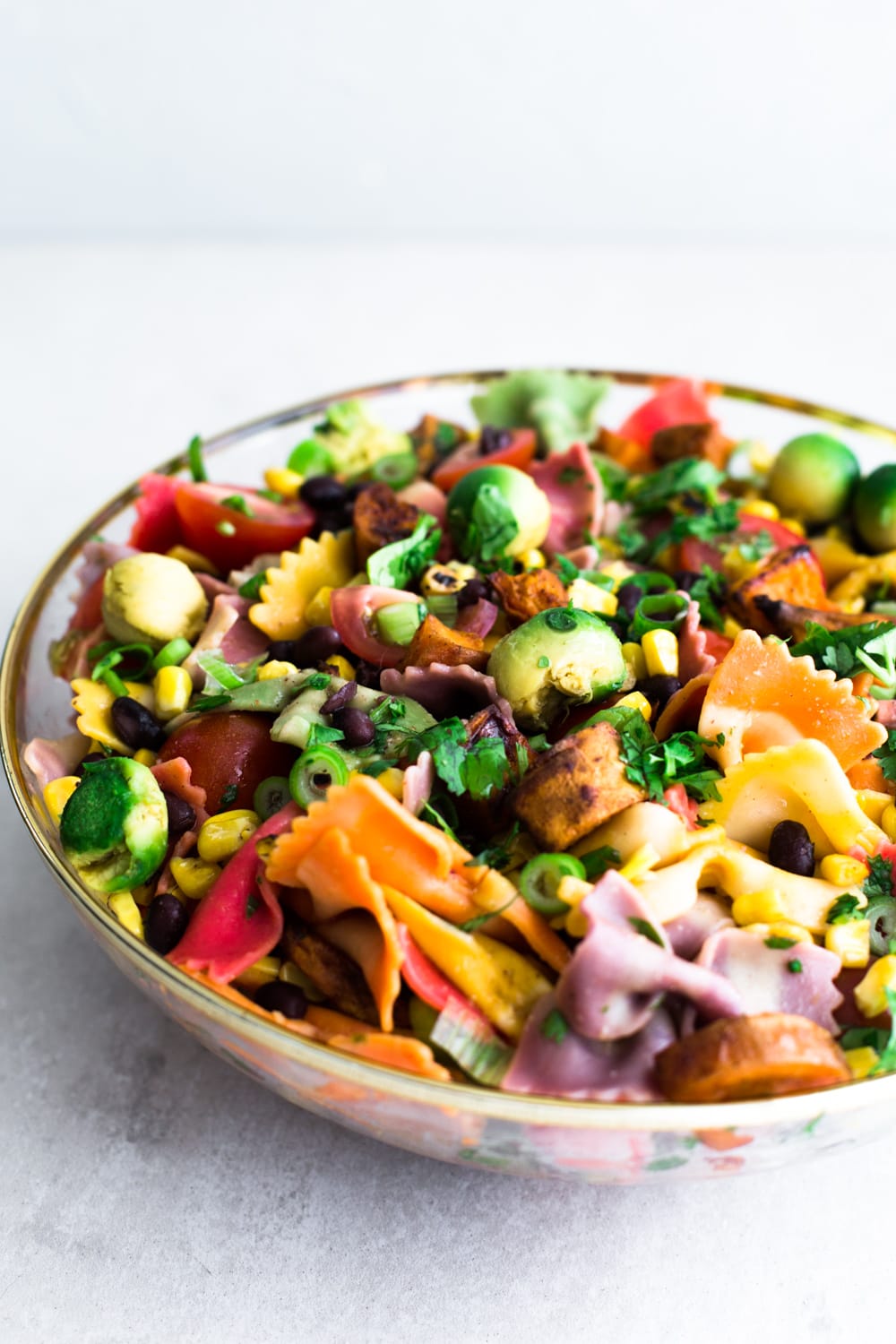 A Mexican inspired Vegan Southwestern Pasta Salad with Roasted Sweet Potato, Grilled Corn, Cherry Tomatoes, Black Beans & a Cumin Lime Vinaigrette. #healthy #vegan #pasta #salad #southwestern #mexican #corn #rainbow #salad #vegetarian #healthyrecipe