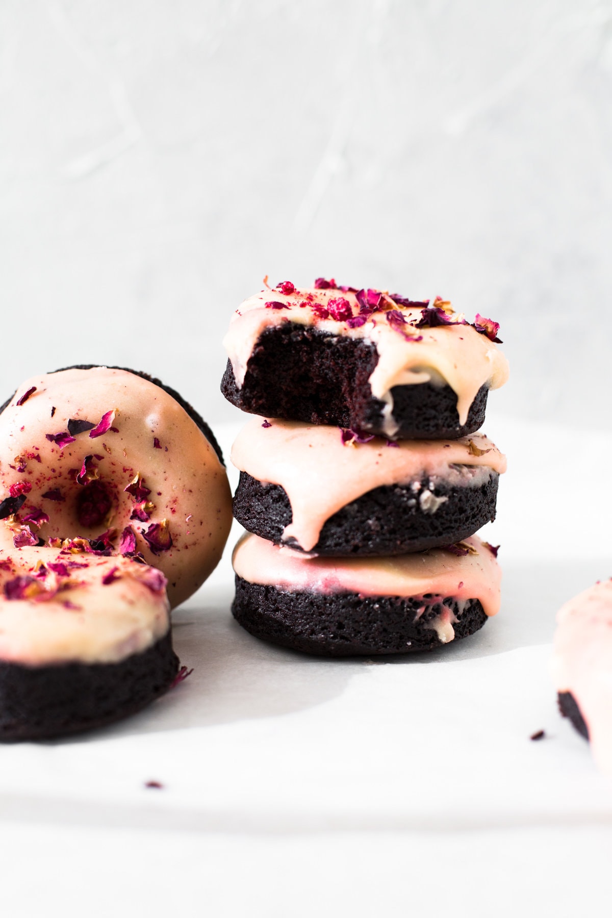 Moist and delicious Vegan Baked Chocolate Donuts topped with a floral Rose Glaze. Easy to make and ready in under 30 minutes. #donuts #vegandonuts #cakedonuts #bakeddonuts #turkishdelight #chocolate #chocolatedonuts #baking #vegetarian #chocolatecake #easy #30minutes