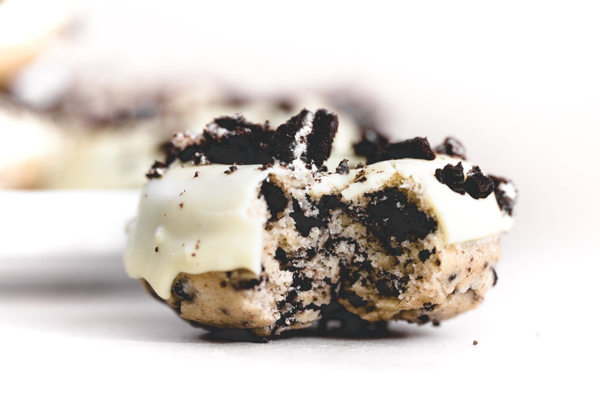 Vegan Oreo Donuts made in under 1 hour. The perfect Baked Vanilla Donuts studded with chunks of Oreo and iced with Vegan White Chocolate. YUMMEH. #vegan #donut #baking #bakeddonut #oreodonut #whitechocolate #cake #oreo #veganbakeddonuts #easy #dairyfree #eggless #simple